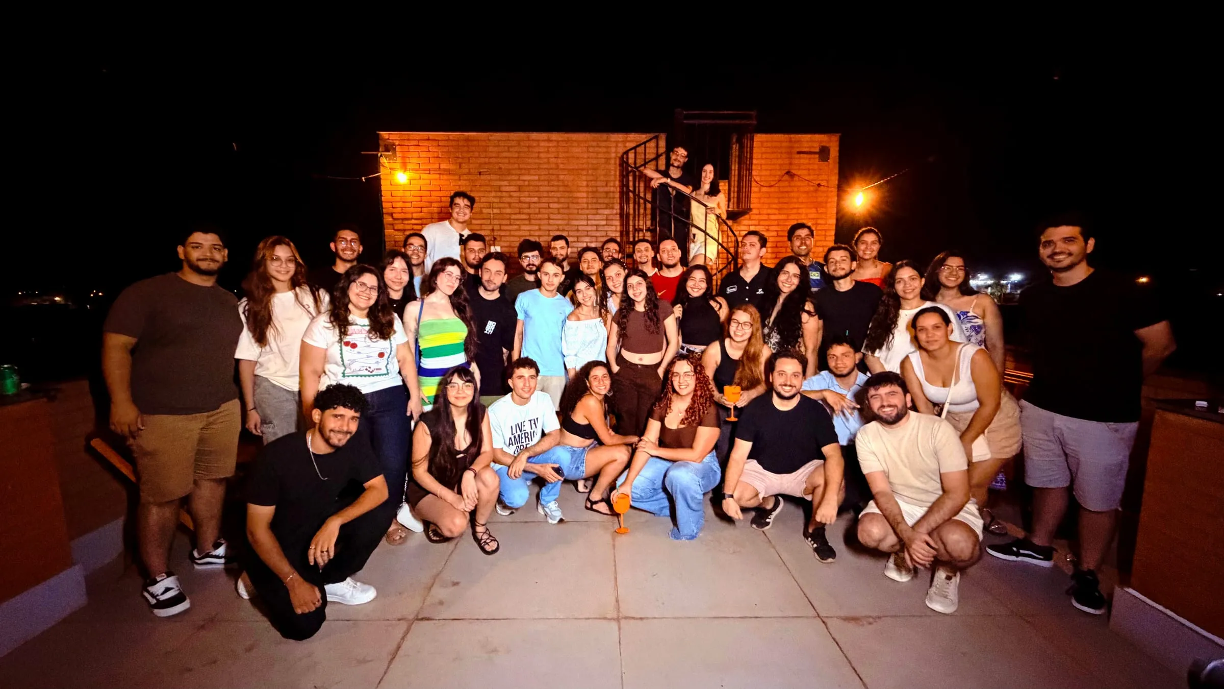 Grupo reunido à noite no terraço de tijolos, no 17º encontro presencial